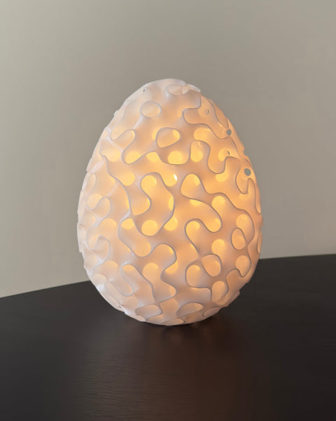 Uovo table lamp — a Schwarz minimal surface closed into an egg, lit from within