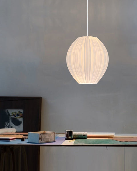 Morandi Cristallo #1 pendant light glowing warmly above a workbench against a concrete wall