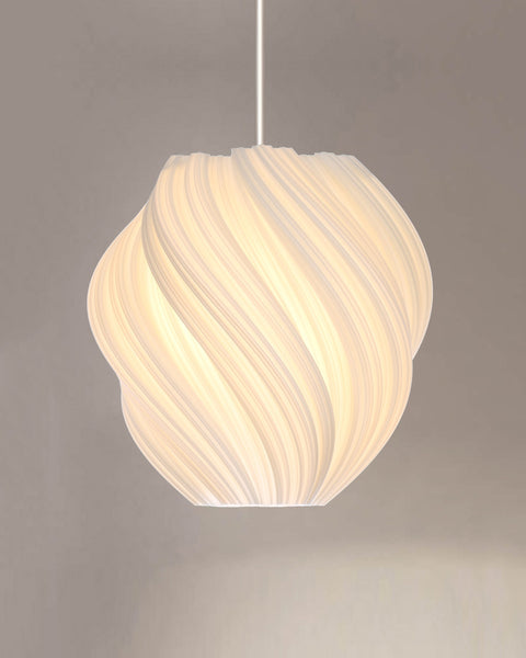 Cristallo #2 Clockwise pendant lit with a warm glow, spiral-ribbed shade on a white cord against a warm grey wall