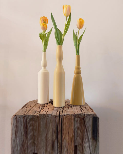 Morandi Vase Set #1 holding yellow tulips on a weathered wooden block against a soft neutral wall